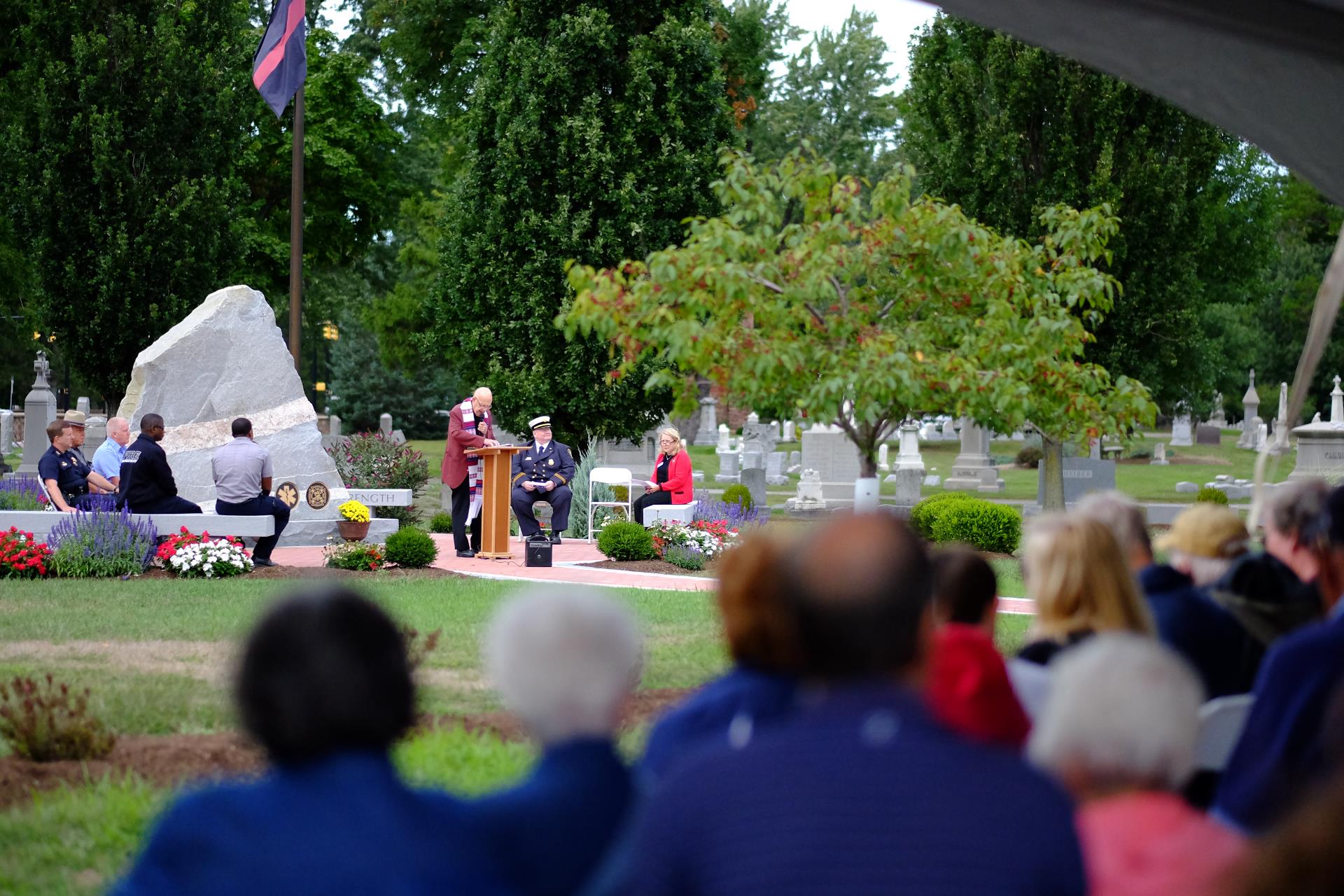 Slide-6-2 service for a first responder in front of a large monument