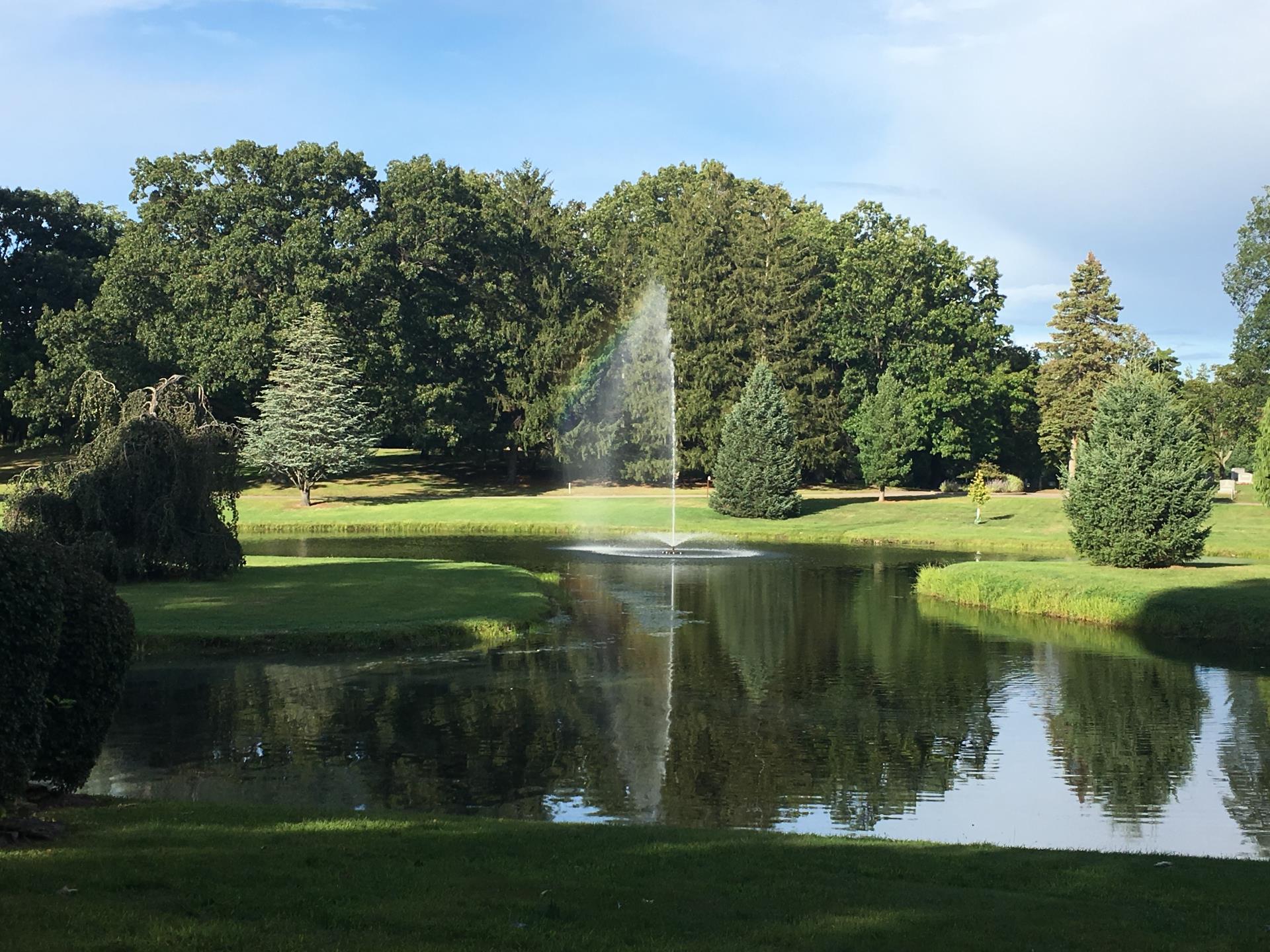 Trinity-Lake image of the green burial section featuring a pond with a fountain