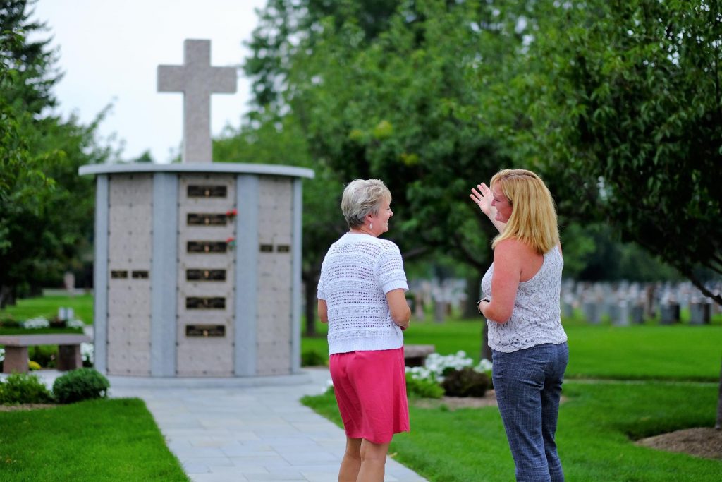 hours-of-operation 2 women near a columbarium